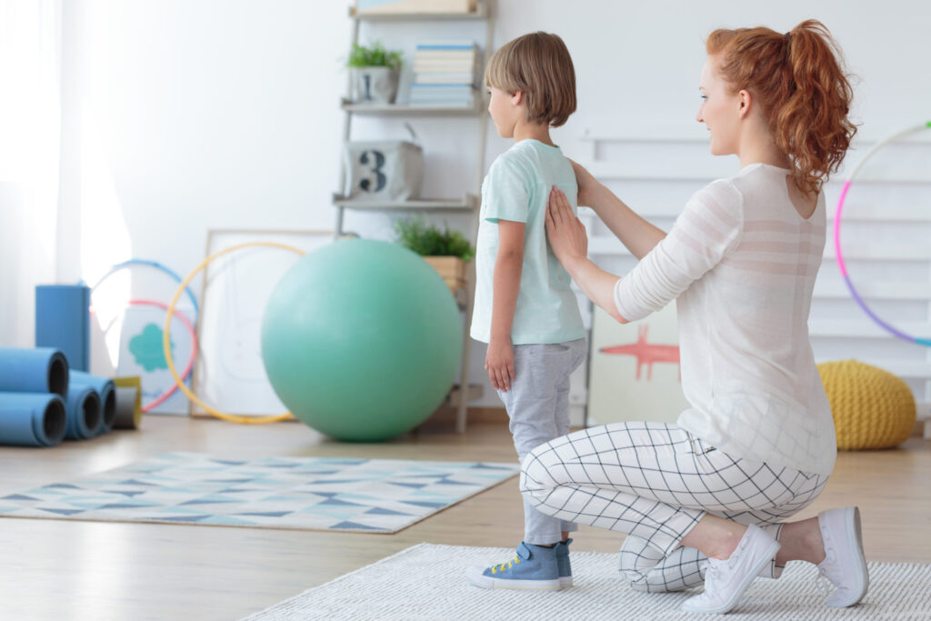 Female,Child,Physiotherapist,Examining,Little,Patient's,Spine,In,Pediatric,Orthopedic