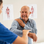 A physiotherapist assisting a senior patient with joint pain exercises in Newmarket clinic