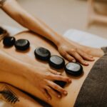 A therapist performing hot stone massage on a client’s back in Vaughan