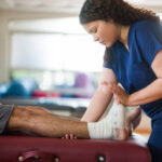 Chiropractor in Newmarket adjusting patient's ankle for pain relief