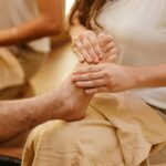 Therapist performing reflexology massage on client’s feet in Newmarket