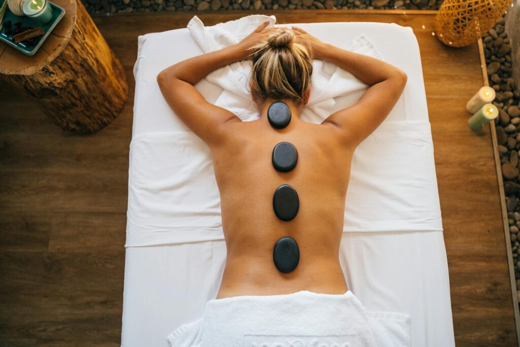 A person receiving a relaxing hot stone massage therapy in Vaughan at PhysioChiroWellness.
