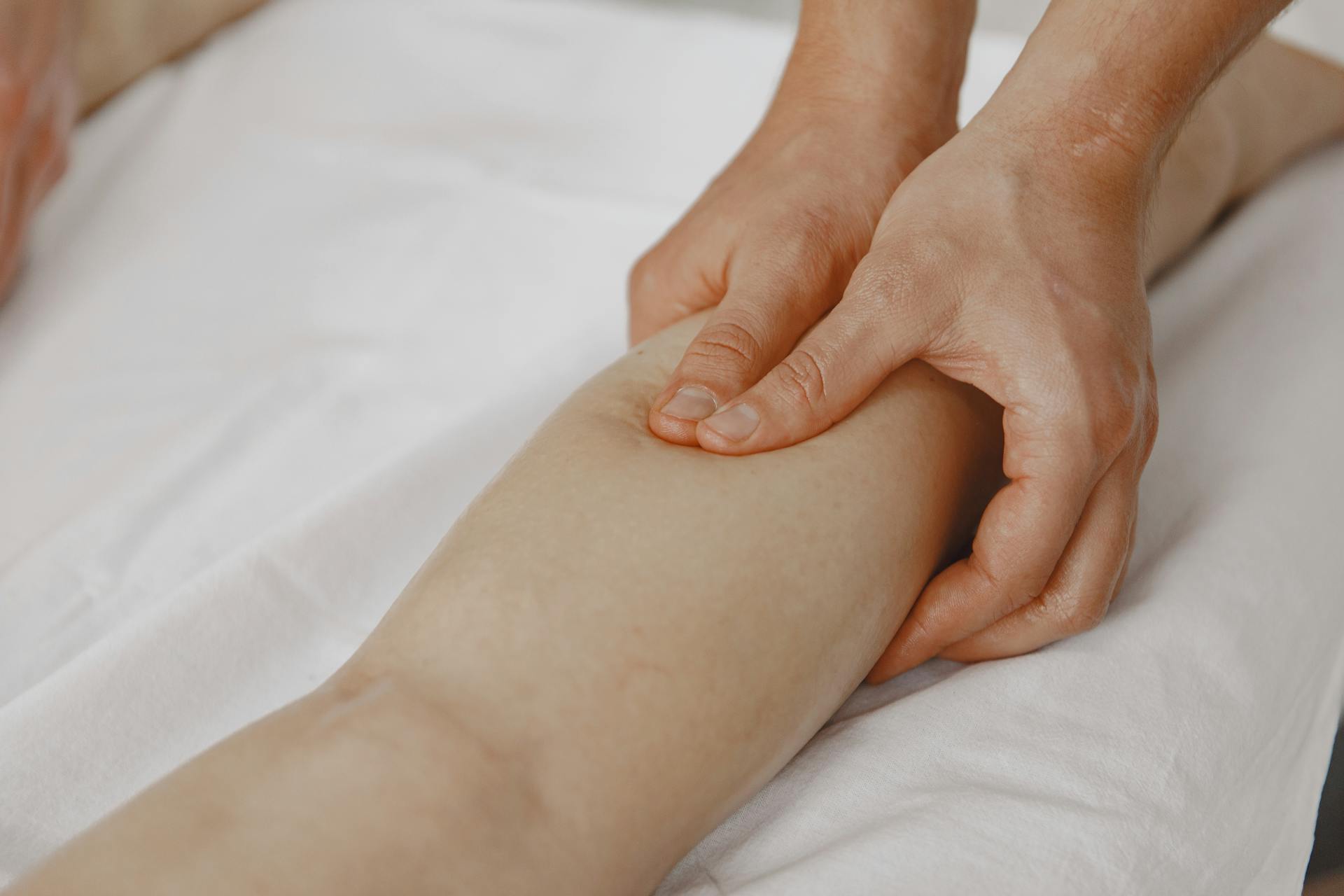 A registered massage therapist in Vaughan working on a client’s calf to relieve muscle cramps.