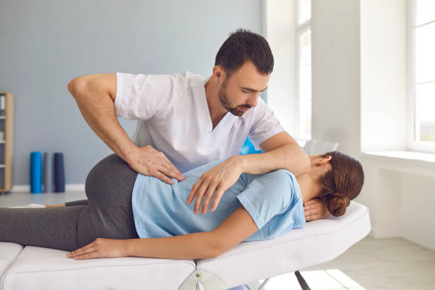 Professional chiropractor in Newmarket performing a gentle spinal adjustment on a patient at PhysioChiroWellness clinic Professional chiropractor in Newmarket performing a gentle spinal adjustment on a patient at PhysioChiroWellness clinic