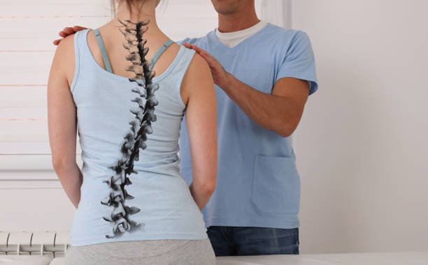 Chiropractor in Newmarket assessing spinal curvature for a scoliosis patient