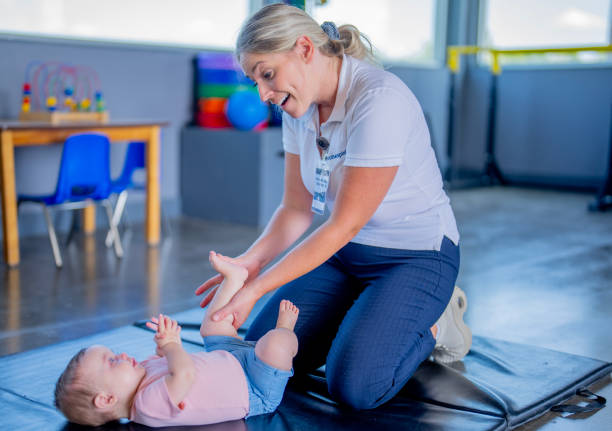 Chiropractor in Newmarket demonstrating proper lifting technique to parents
