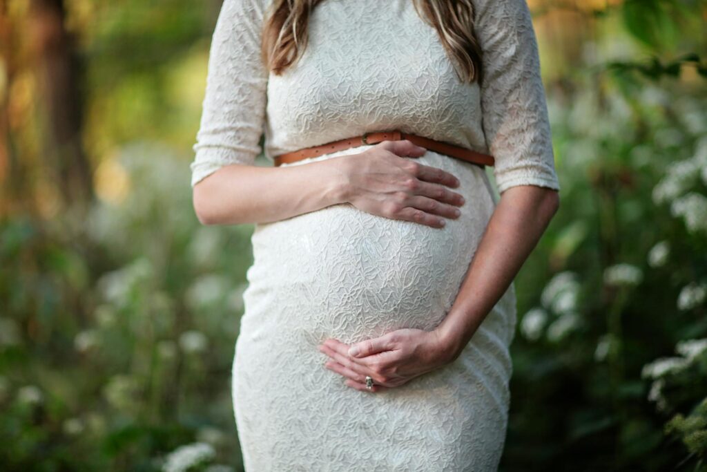 Pregnant woman holding her belly symbolizing natural fertility and reproductive health through naturopathy in Newmarket.