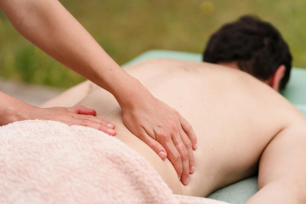 A therapist performing focused deep tissue massage on a client's shoulders in a Newmarket clinic