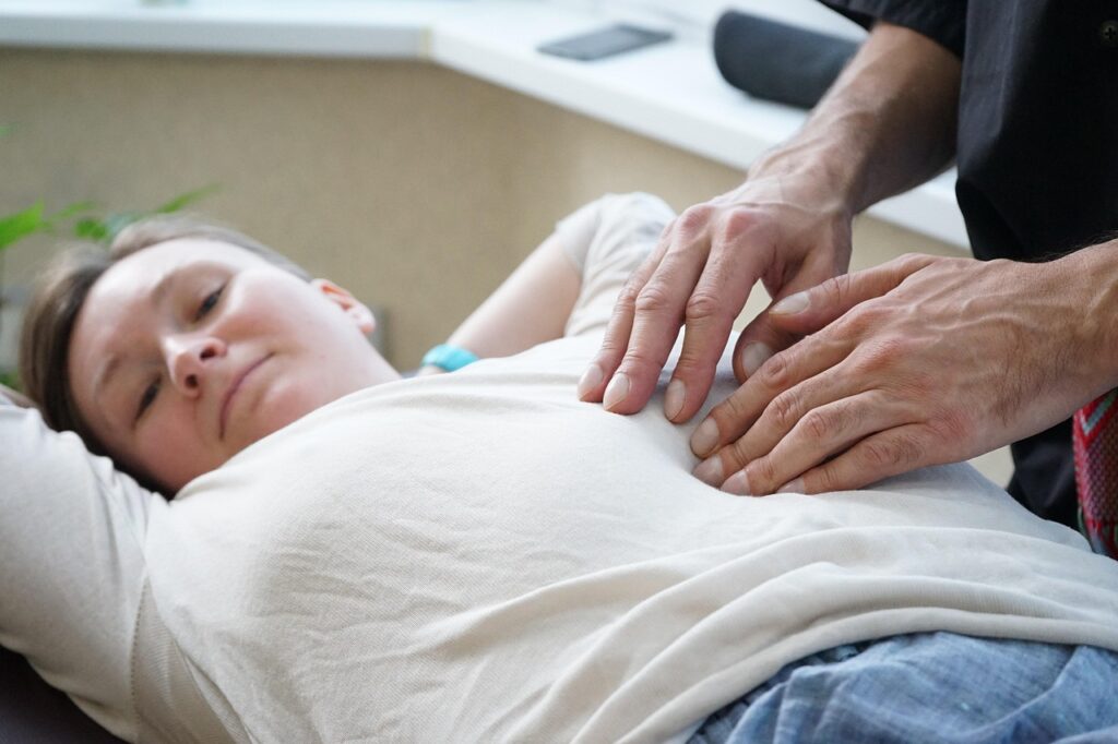 A therapist performing gentle abdominal massage in Newmarket clinic setting