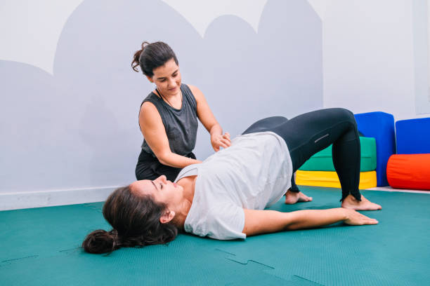 Pelvic floor physiotherapist guiding new mom through postpartum recovery exercises in Vaughan clinic