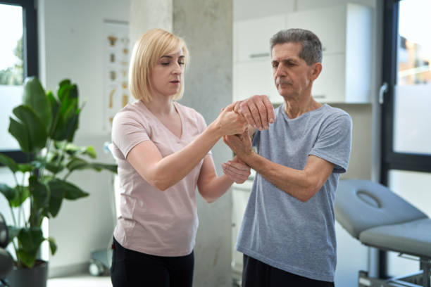 A physiotherapist IN Vaughan helping older adult stretch to reduce arthritis pain during therapy session