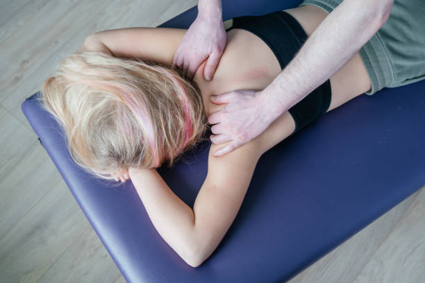 Massage therapist in Newmarket performing myofascial release on patient’s back