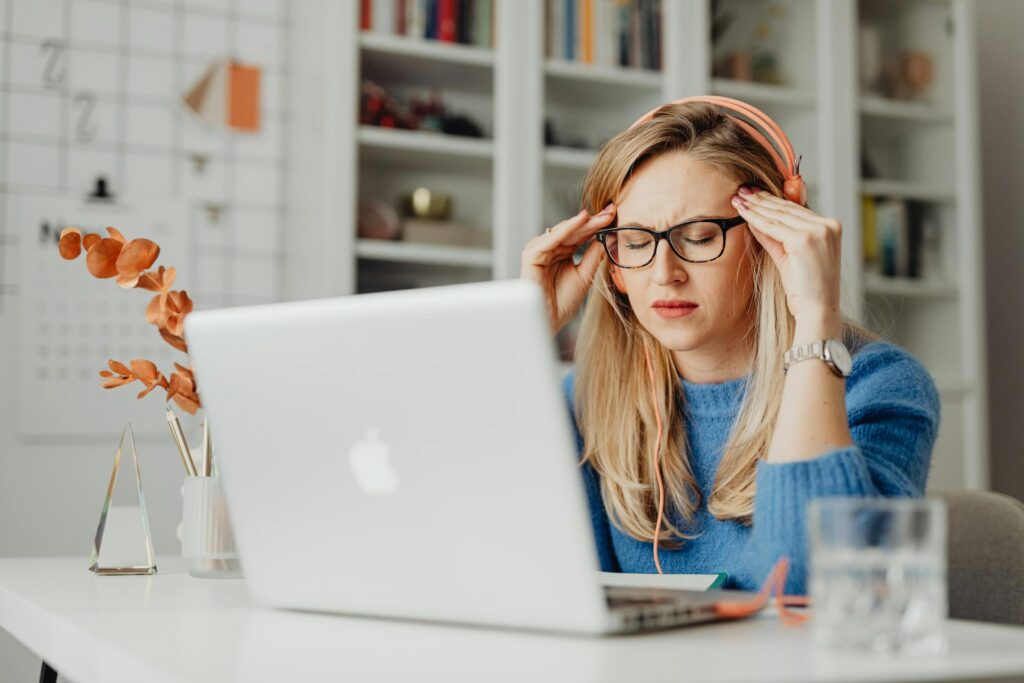 Office worker with forward head posture at desk, a common cause of tension headaches in Newmarket