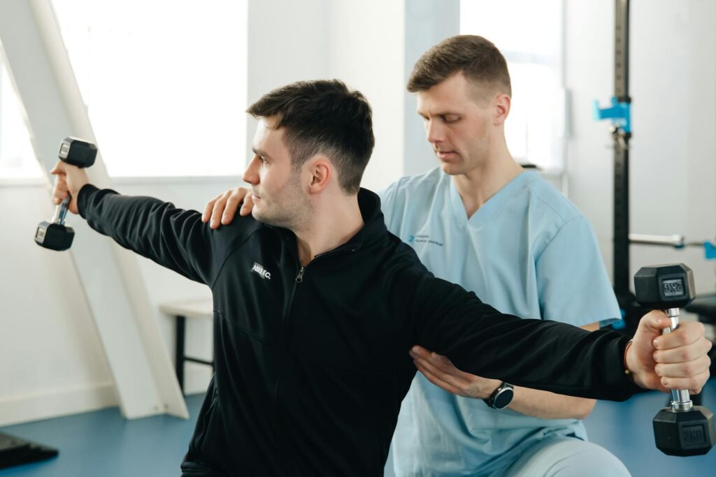 A Physiotherapist assessing a patient's shoulder mobility during a physiotherapy session in Newmarket